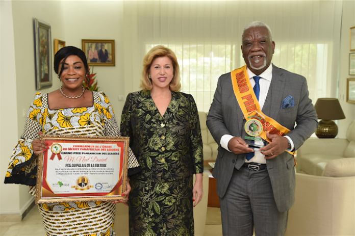 Distingué à Casablanca ( Maroc) Noël Dourey présente son prix à la Première Dame Dominique Ouattara